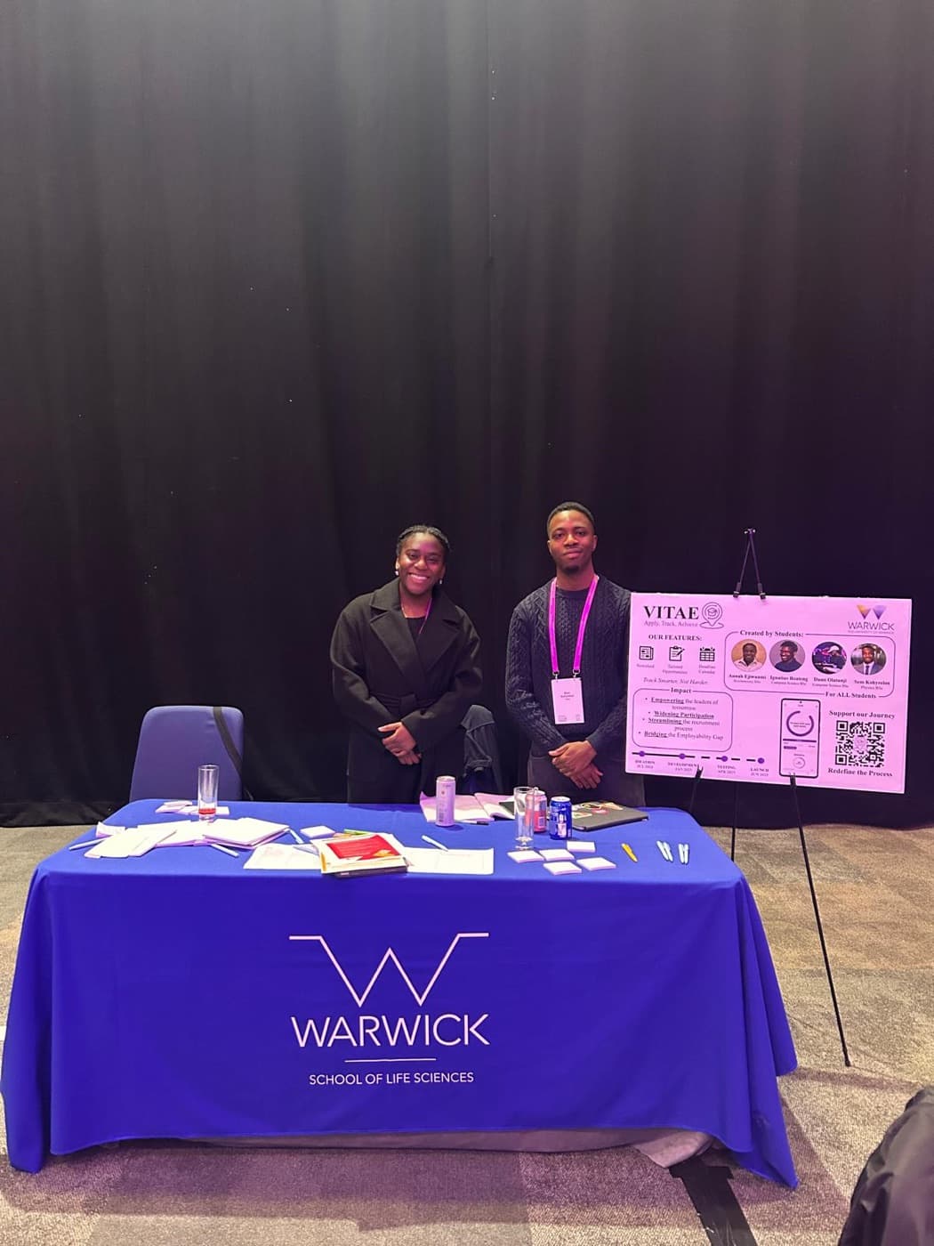Two members of the Vitae team behind a University of Warwick School of Life Sciences table at MLSFF 2025